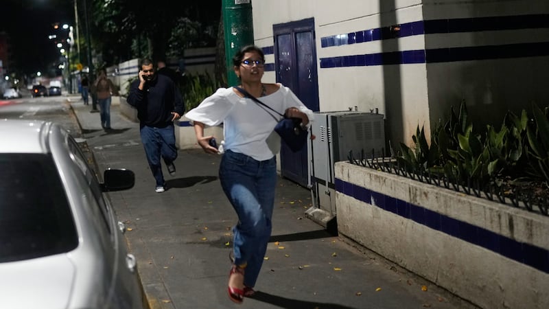 Pedestrians run after explosions and low-flying aircraft were heard in Caracas, Venezuela,...