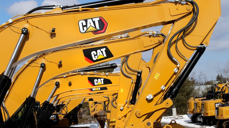 FILE - Excavator booms, adorned with the Caterpillar Inc. "CAT" logo, are displayed at the...
